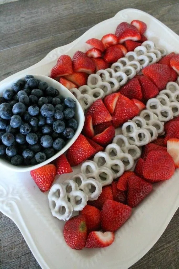 Colorful 4th of July fruit platter shaped like the American flag with desserts.