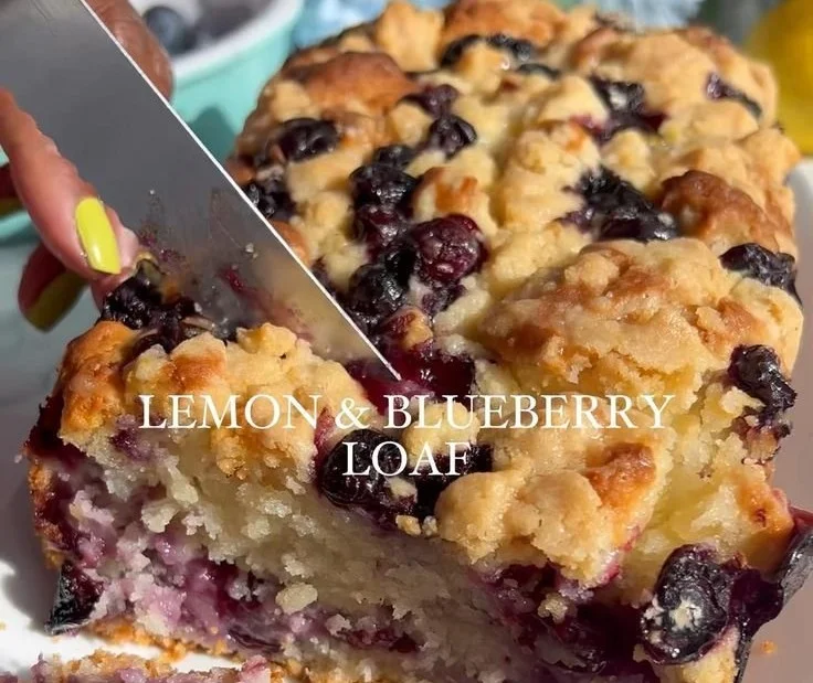 Slice of Blueberry Lemon Loaf with blueberries and lemon zest on a plate
