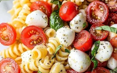 A colorful bowl of Caprese Pasta Salad with tomatoes, basil, and mozzarella.