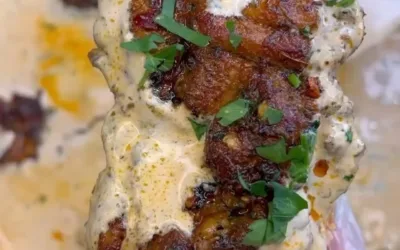 Plate of creamy garlic herb Cajun chicken thighs garnished with fresh herbs