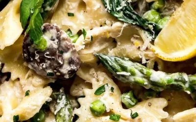 Creamy lemon asparagus pasta dish garnished with lemon zest and asparagus spears.