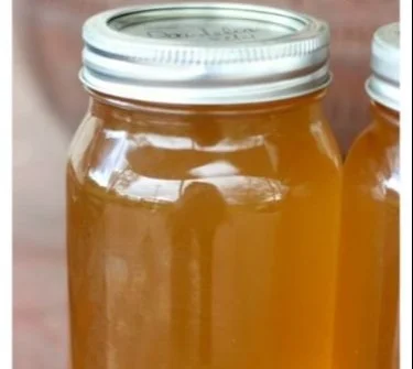 Delicious jar of homemade Dandelion Jelly on a wooden table