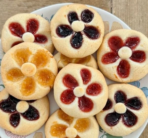 Flower Jam Thumbprint Cookies with fruity jam center on a plate