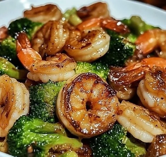 High-protein honey garlic shrimp served with vegetables and rice on a plate.