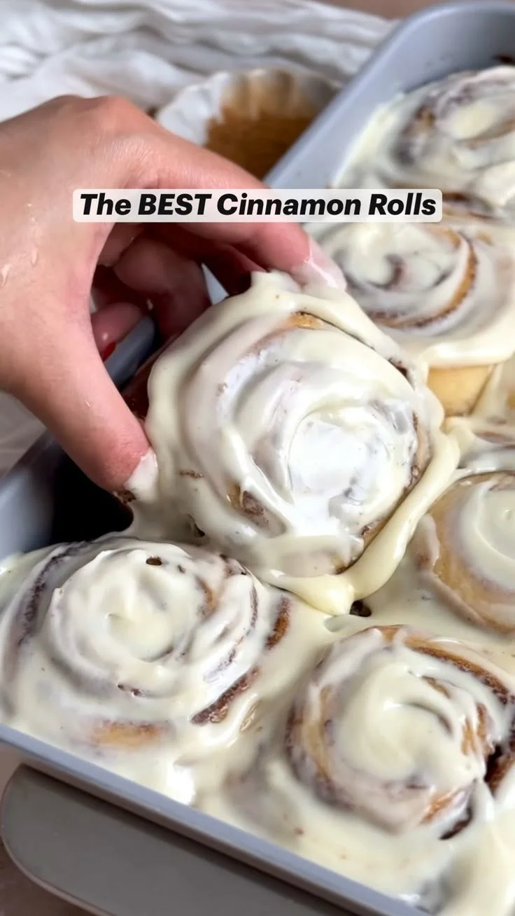 Delicious homemade cinnamon rolls topped with icing on a plate