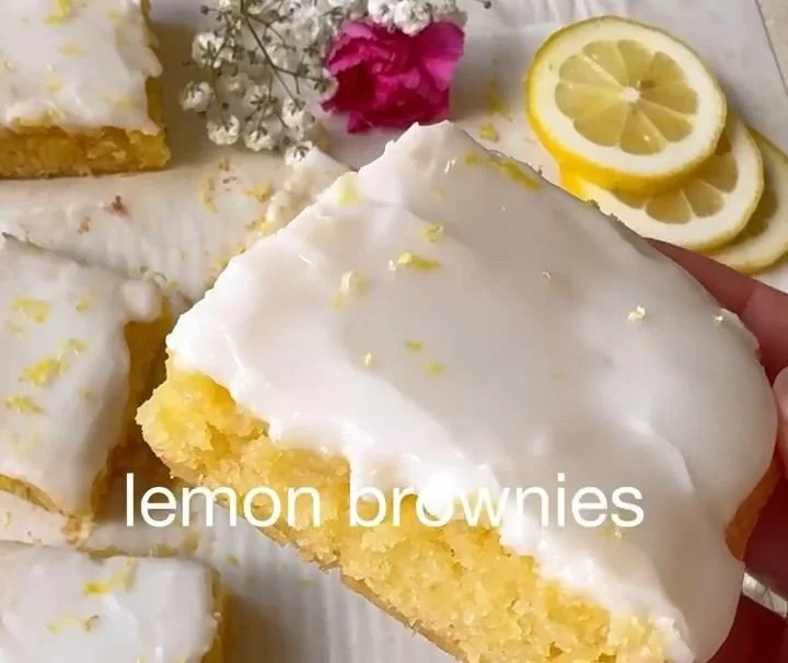 Delicious lemon brownies topped with lemon zest and powdered sugar