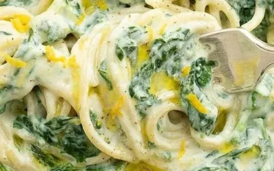 Plate of lemon ricotta pasta with spinach and garnished with herbs
