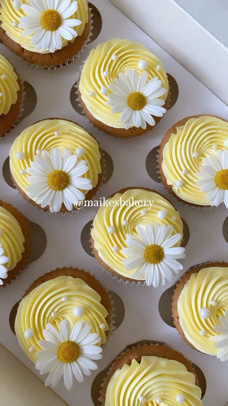 Pastel yellow cupcakes decorated with daisies and pearls for a festive touch