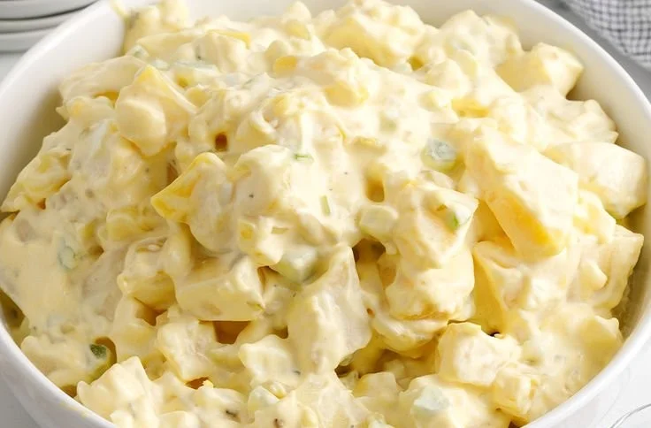 Delicious homemade potato salad served in a bowl with herbs and spices.