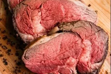 A perfectly cooked Standing Rib Roast with herbs and spices on a serving platter