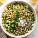 Jennifer Aniston salad in a white bowl with quinoa, chickpeas, cucumber, herbs, and feta