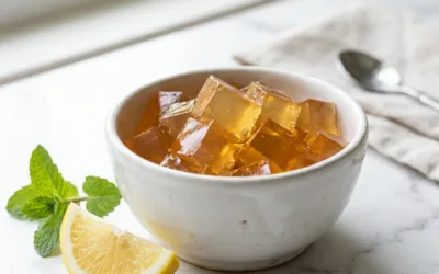 Finished jello recipe for weight loss cubes in white ceramic bowl with lemon on marble