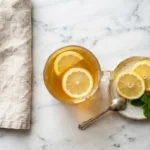 Jillian Michaels gelatin hack morning tonic in a glass mug with lemon